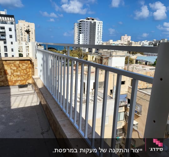 מעקה מתכת לבן על מרפסת עם נוף עירוני